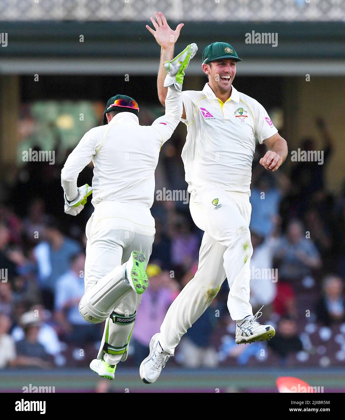 Le marais Mitch d'Australie saute dans les airs avec son coéquipier Tim Paine alors qu'il célèbre le départ de Joe Root d'Angleterre pendant le jour 1 du cinquième match de test entre l'Australie et l'Angleterre au terrain de cricket de Sydney à Sydney, jeudi, 4 janvier 2018. (AAP image/David Moir) Banque D'Images