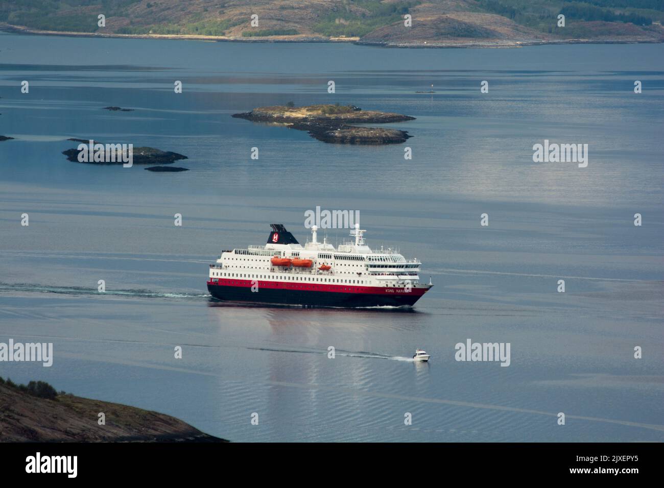 Hurtigrluten navire Kong Harald passant le dôme de granit de Torghatten dans le centre de la Norvège tout en quittant Brønnøysund. Banque D'Images