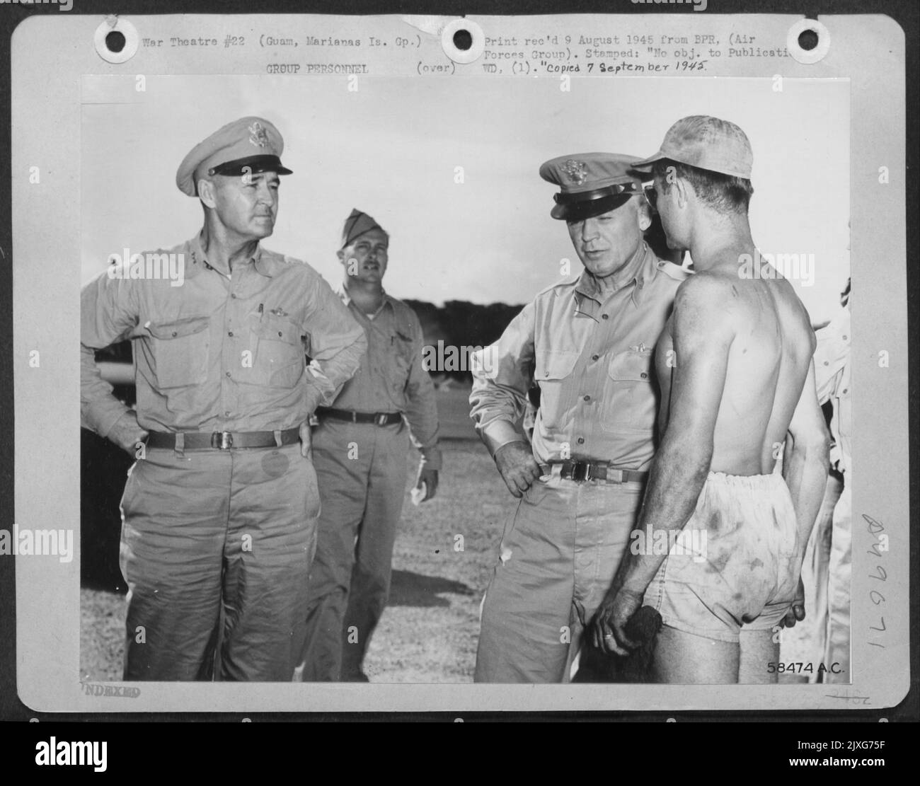 Le chef des forces aériennes de l'Armée de terre, le général Henry H. Arnold, écoute Un rapport d'Un chef d'équipage surperfortress sur Guam. De gauche à droite : Lieutenant-général Barney M. Giles, commandant général de l'AAF, zones de l'océan Pacifique; colonel Elbert D. Reynolds, commandant de L'A 3 Banque D'Images
