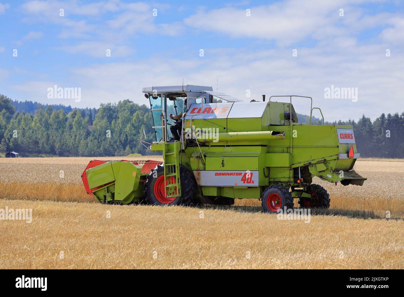 Agriculteur moissonnant un champ de blé mûr avec la moissonneuse-batteuse Claas Dominator 48S par un beau jour d'août. Salo, Finlande. 27 août 2022. Banque D'Images