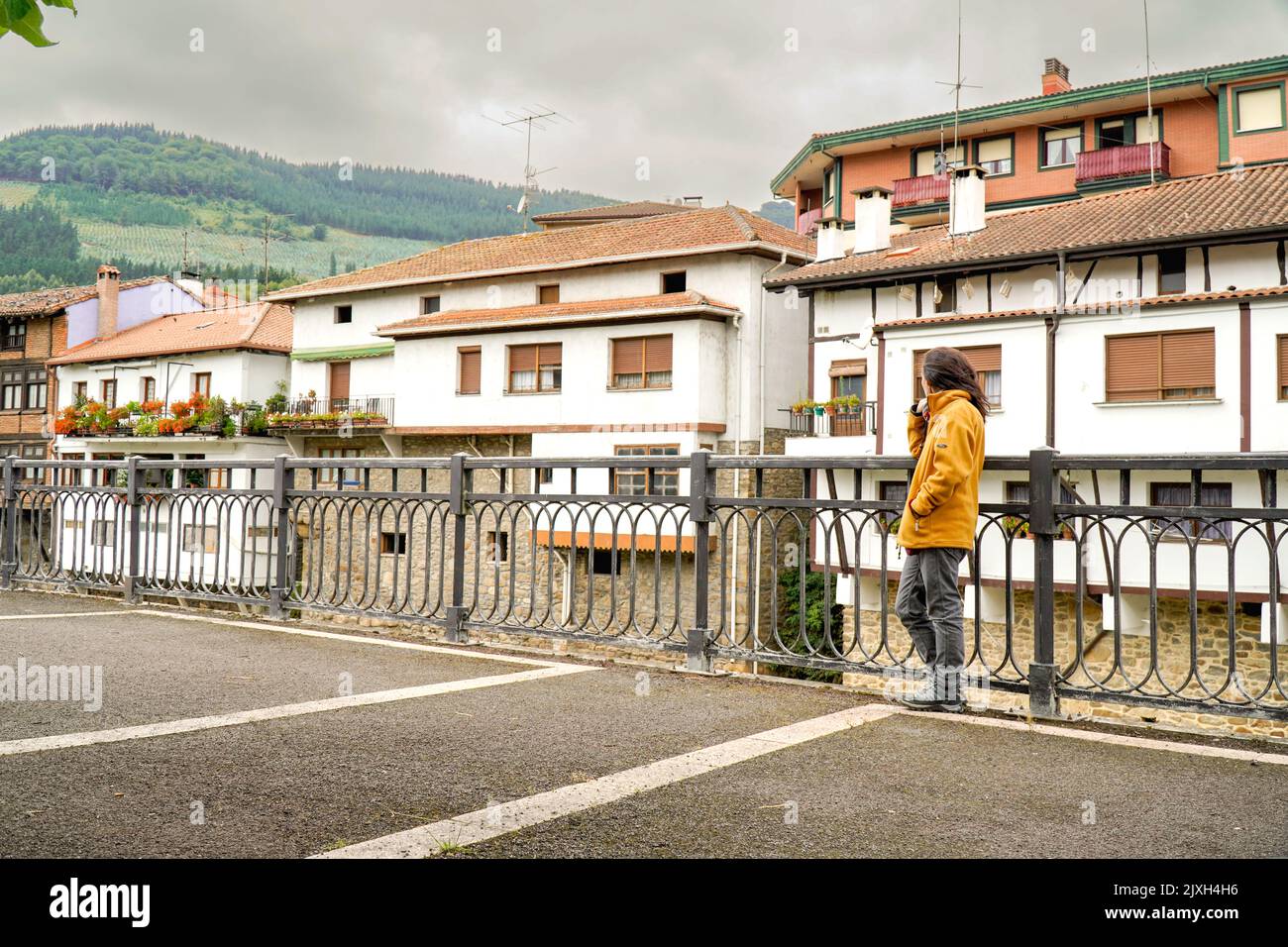 Femme regarde les vieilles maisons basques à Orozko Banque D'Images