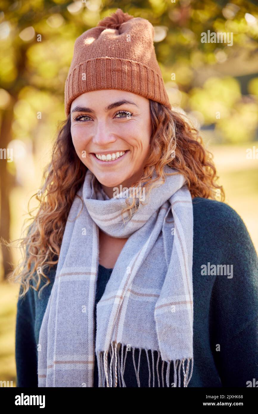 Portrait d'une jeune femme souriante portant un chapeau et une écharpe dans le parc d'automne Banque D'Images