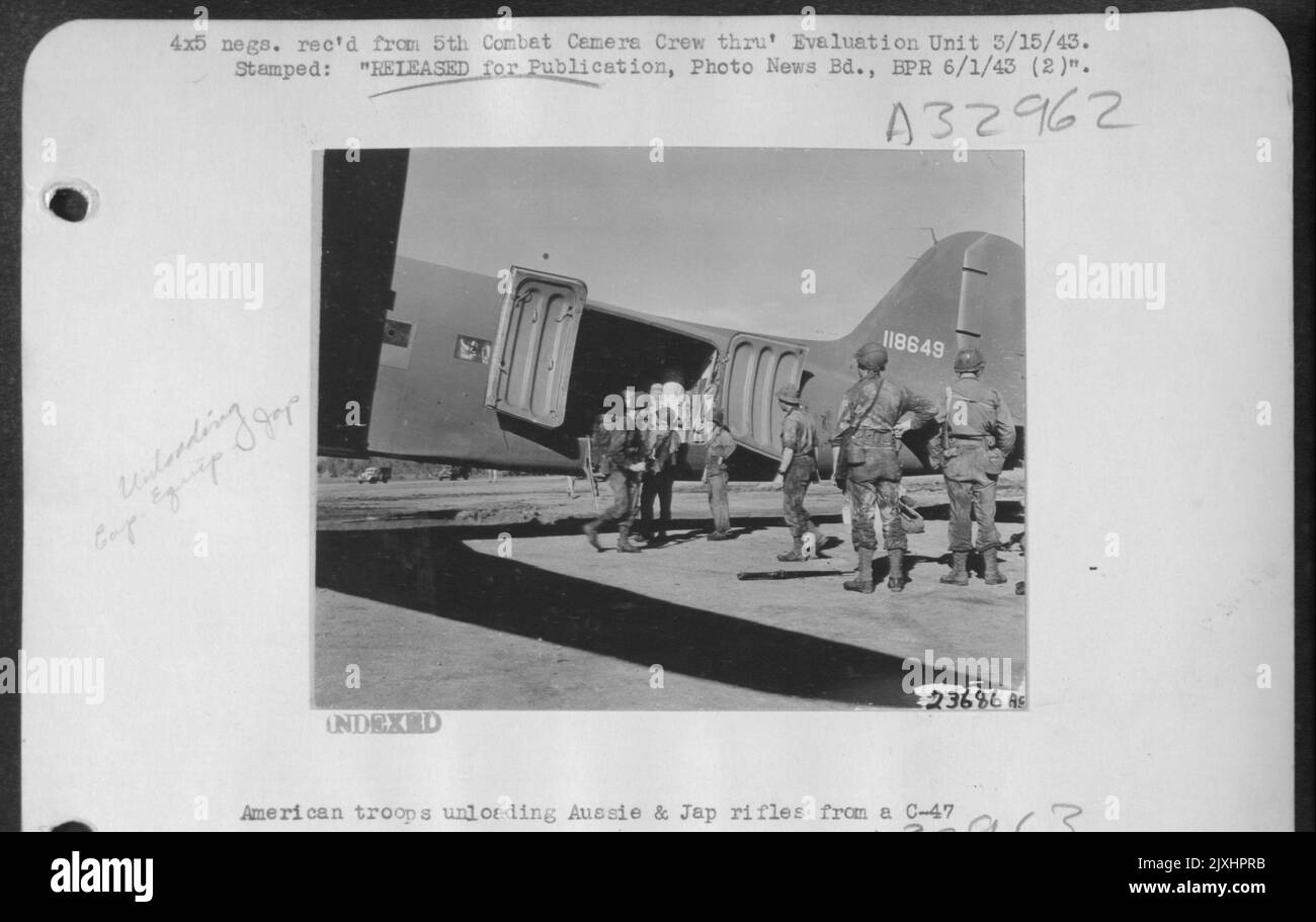 Des troupes américaines déchargent des fusils australiens et japonais d'un C-47 Banque D'Images