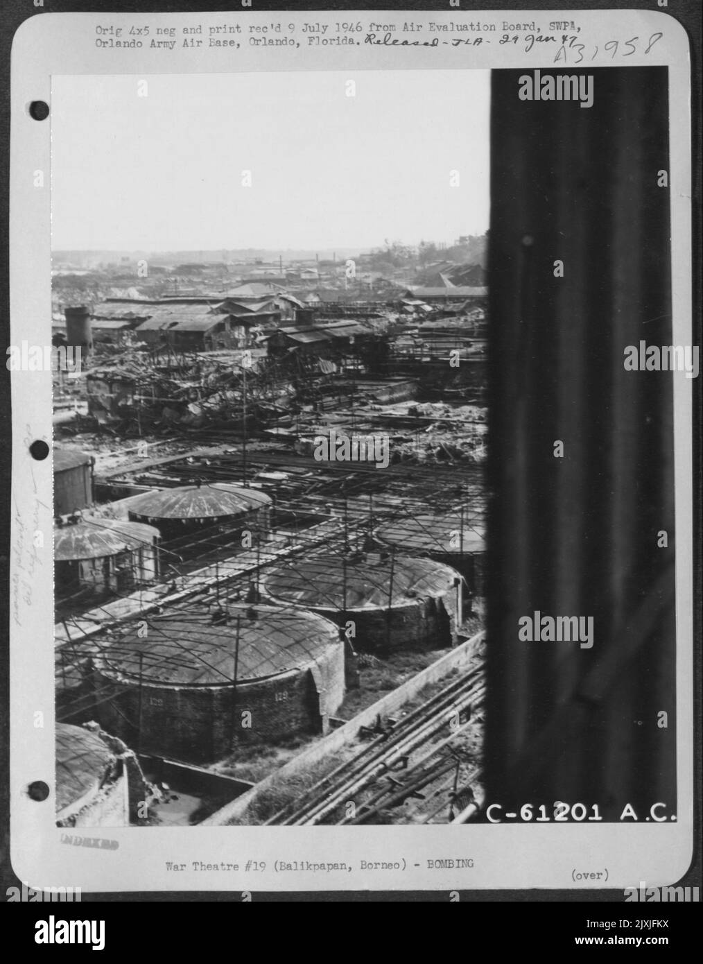 Vue générale de l'ancien Balikpapan Borneo, zone de raffinerie, montrant la destruction de la centrale électrique en arrière-plan. Notez la méthode de camouflage sur les réservoirs. Le fil de poulet étiré sur les poteaux était alors recouvert de végétation. 14 août 1945. Banque D'Images