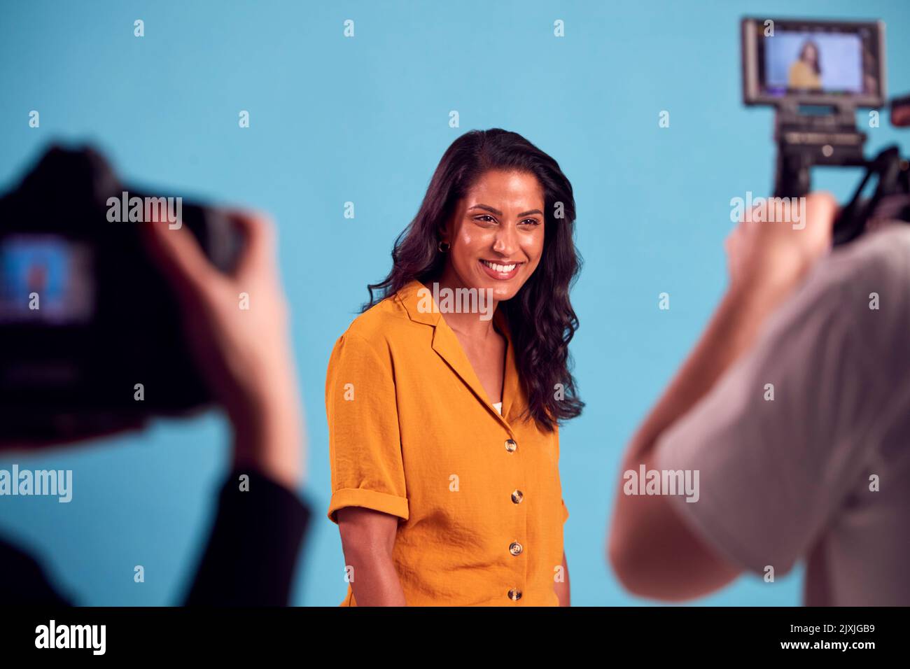 Femme mature en studio sur tournage avec caméra vidéo et Stills Banque D'Images