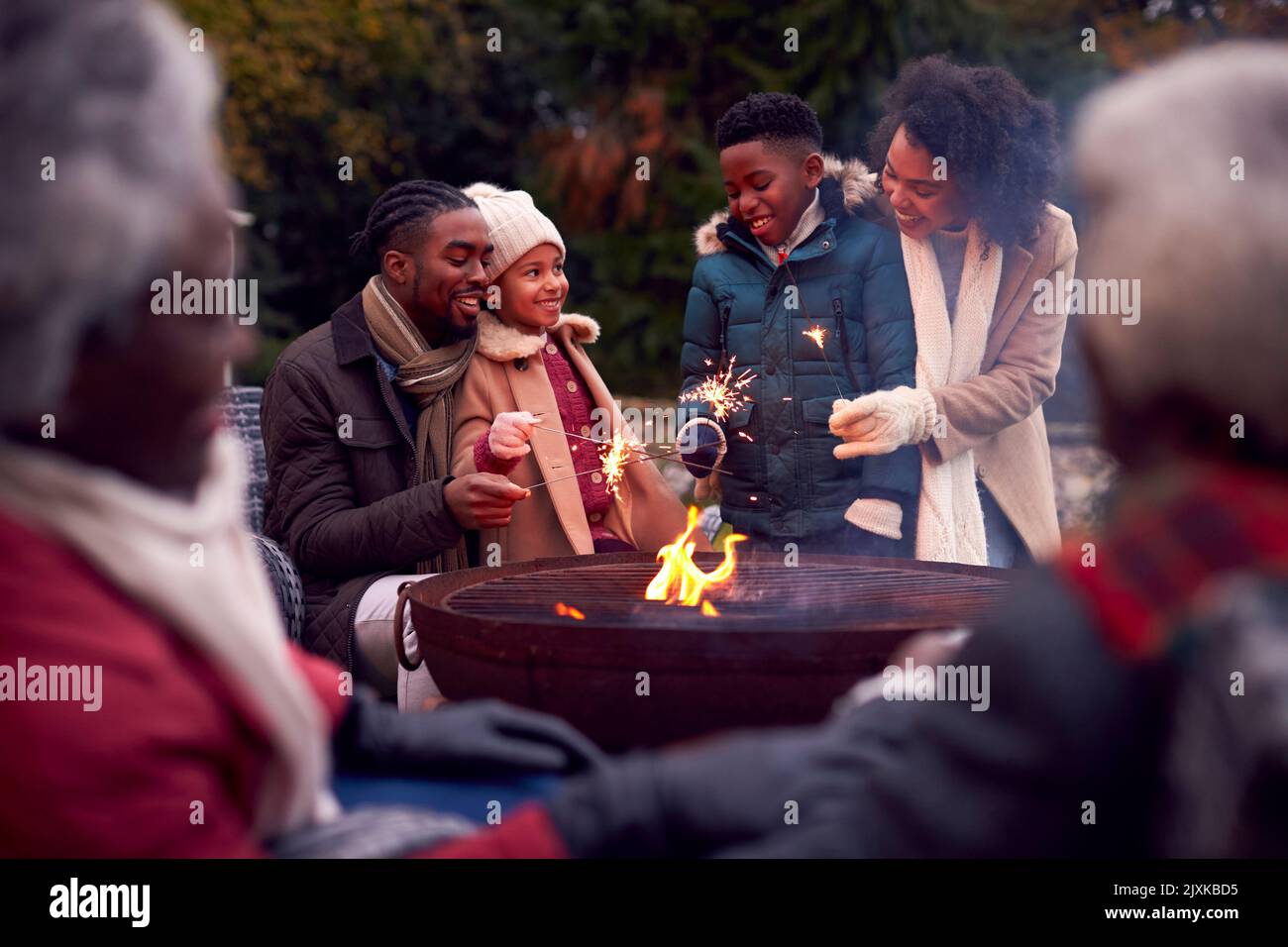 Famille multi-génération s'amuser avec les feux d'artifice dans le jardin d'automne ensemble Banque D'Images