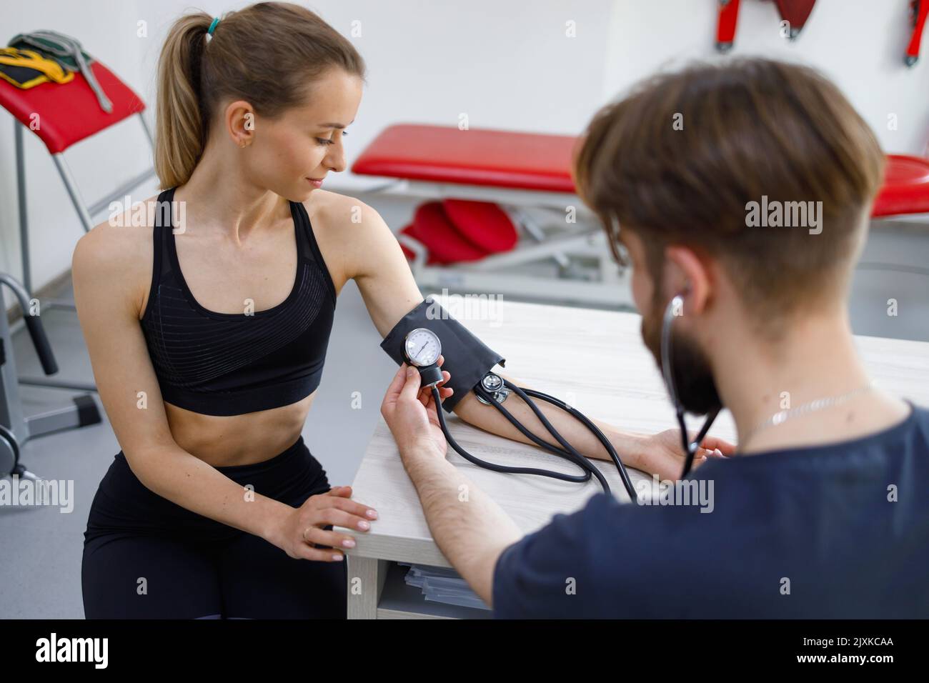 Le médecin mesure la tension artérielle à la femme dans les vêtements — free download