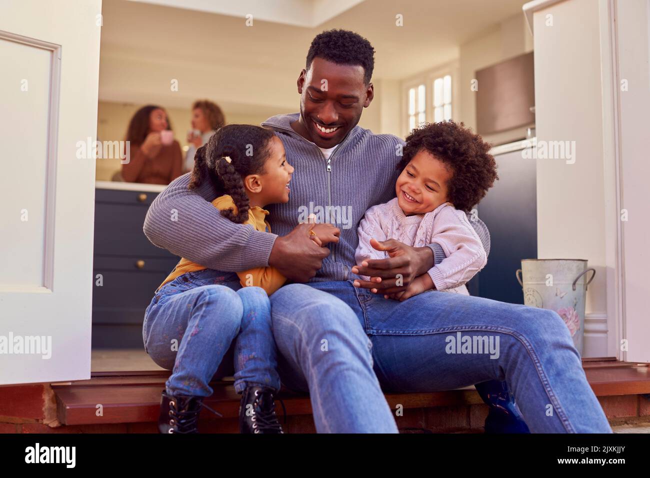 Père et enfants assis sur Step at Home mettre des bottes avant de partir à la promenade en famille Banque D'Images