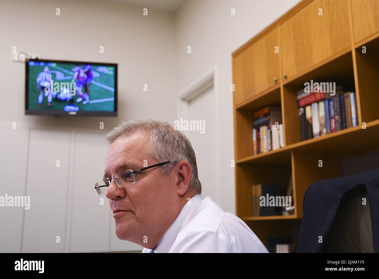 Une télévision montrant le clash de la série 24 de la NRL entre les requins Cronulla-Sutherland et les chevaliers de Newcastle est vue derrière le Premier ministre australien Scott Morrison lors d'une rencontre avec le trésorier australien Josh Frydenberg au Parlement à Canberra, dimanche, 26 août 2018. (Image AAP/Coch Lukas) Banque D'Images