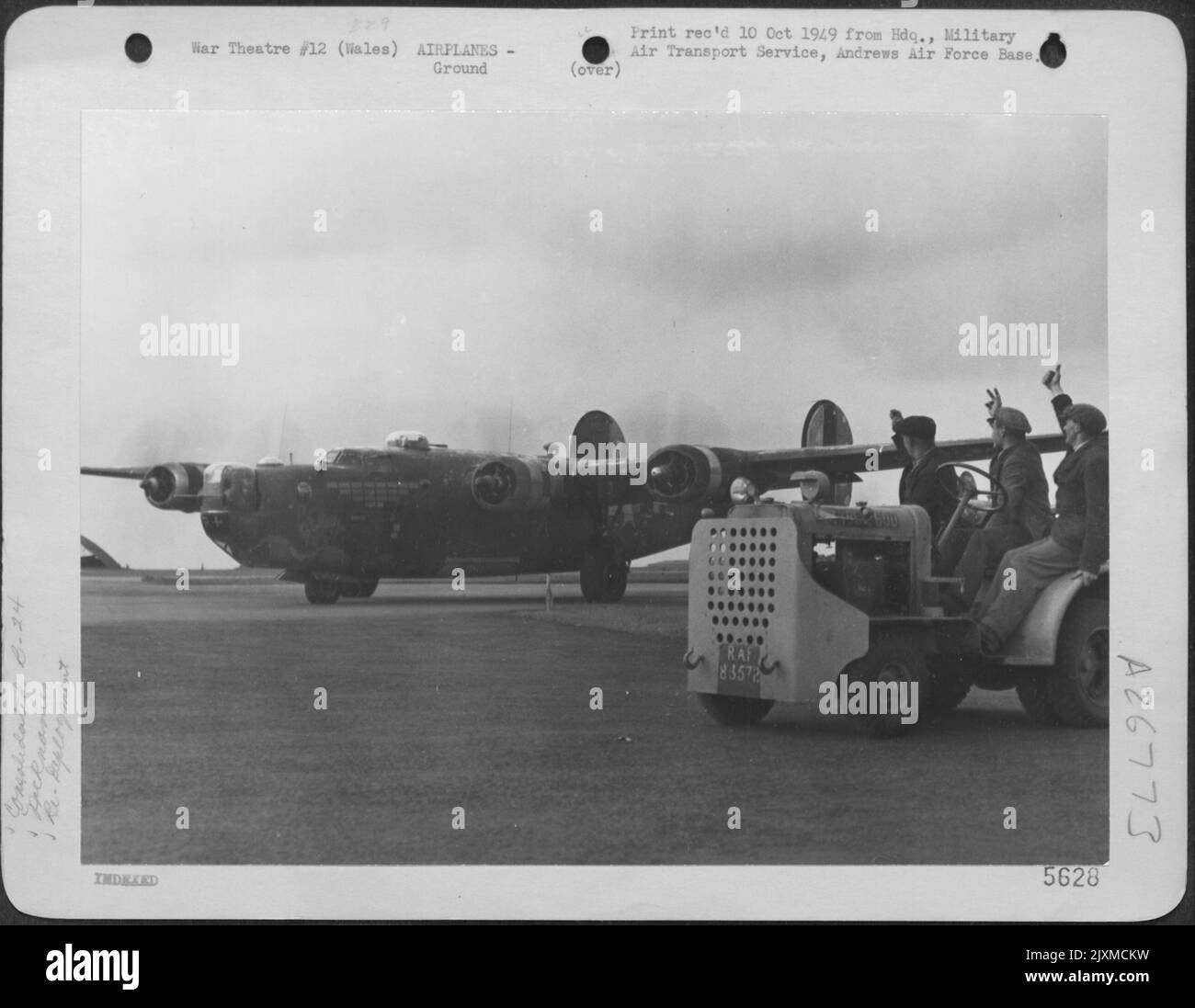 LA COMMANDE DE TRANSPORT AÉRIEN ACCÉLÈRE LA HUITIÈME AAF EN COURS DE ROUTE. Les travailleurs civils britanniques d'une base de commandement du transport aérien des États-Unis à Valley, au pays de Galles, font leurs adieux tandis que la huitième Air Force Consolidated B-24 'GLORY BEE' se prépare à partir pour Banque D'Images