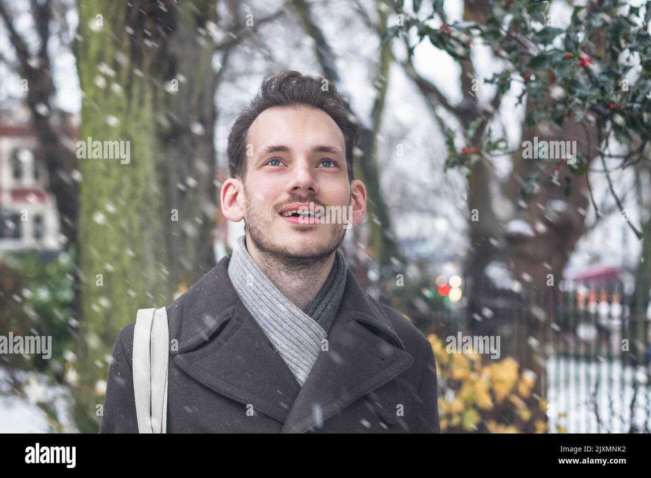 Portrait d'un beau jeune homme dans la neige d'hiver Banque D'Images