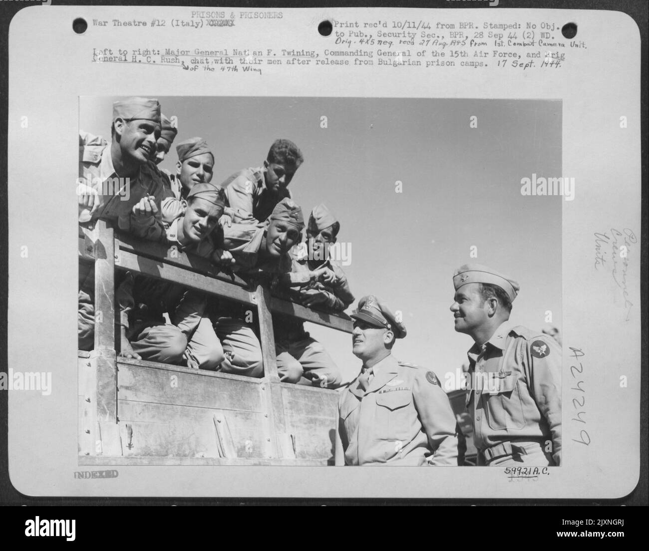 De gauche à droite : le major général Nathan F. Twining, commandant général de la Force aérienne de 15th, et Brig. Général H.C. Rush [de l'aile 47th], discuter avec leurs hommes après leur libération des camps de la prison bulgare. 17 septembre 1944. Banque D'Images