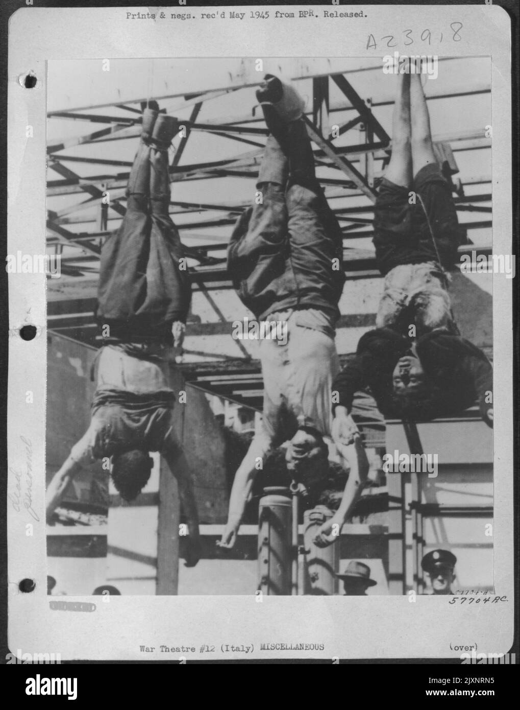 De gauche à droite: Achillf Starace, ancien secrétaire du Parti fasciste, Mussolini, et Claretta Petacci, maîtresse de Mussolini, suspendu d'Un front de station de remplissage dans le centre de Milan après qu'ils ont été tirés par des Patriots italiens. Italie. Banque D'Images