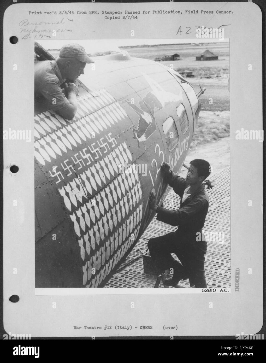 Sgt. Yue Kee, 769 Sacramento St., San Francisco, Californie, un tireur de taille sur un Boeing B-17 Forteresse volante de l'AAF 15th en Italie, craie '123' sur 'Bachelor's Delight', après que ce fort ait terminé sa mission de 123rd sur le territoire ennemi. ASS Banque D'Images