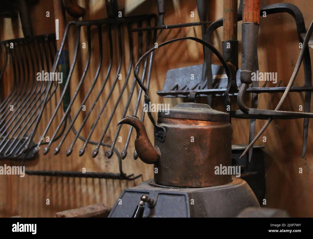Atelier ancien avec de vieux outils et une théière sur un poêle à gaz Banque D'Images