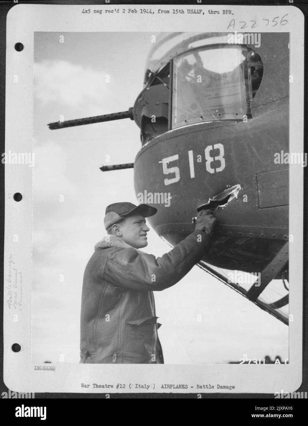 Sgt. Robert F. Hahn, Rochester, New York, canon à tourelle de nez sur un bombardier B-24 Liberator consolidé de 15th AAF, examine un trou fabriqué par une coquille de 20 mm d'un combattant allemand. La coque s'est avérée être un dud, et n'a pas explosé après avoir pénétré le Banque D'Images