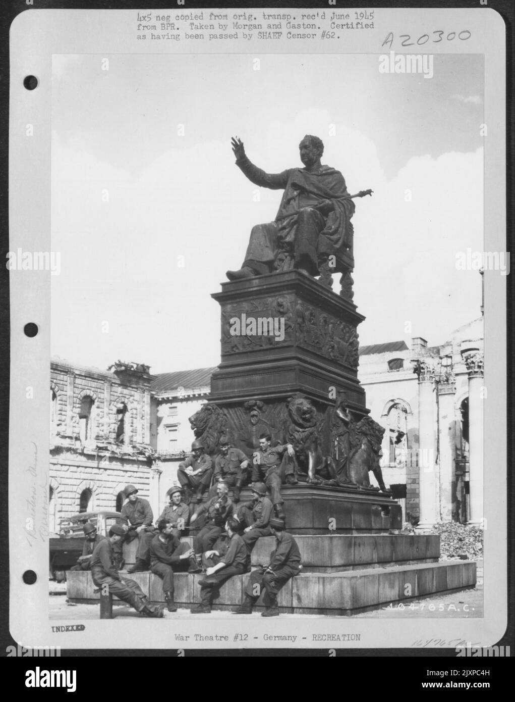 Sous la statue de Maximillian avec son violon se trouve Otto Sattler, Violoniste professionnel juif de Prague, Czechslovakia. Sattler a récemment été libéré du camp pénitentiaire de Dachu et a été adopté par l'infanterie de 232nd. Certains des députés Banque D'Images