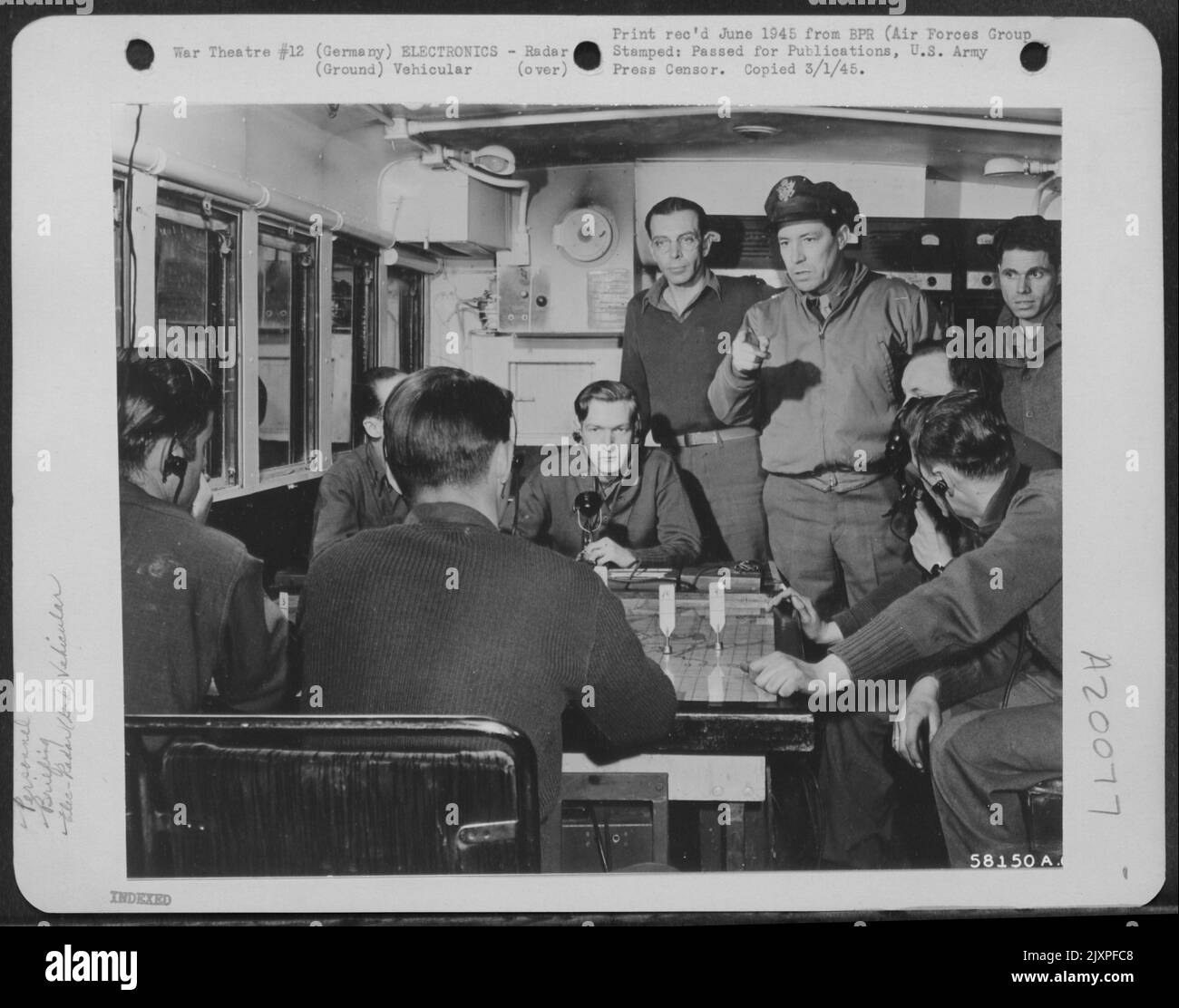 Allemagne - général de division E.R. Quesada, commandant de 9th TAC AF, ETO, (doigt de pointage) met l'accent Sur Un point dans Une fourgonnette de contrôle d'équipement radar mobile. Sur Une carte de grande taille, les techniciens effectuent un tracé des données recueillies par l'équipement radar. Dans les opérations de fermeture, telles que T Banque D'Images