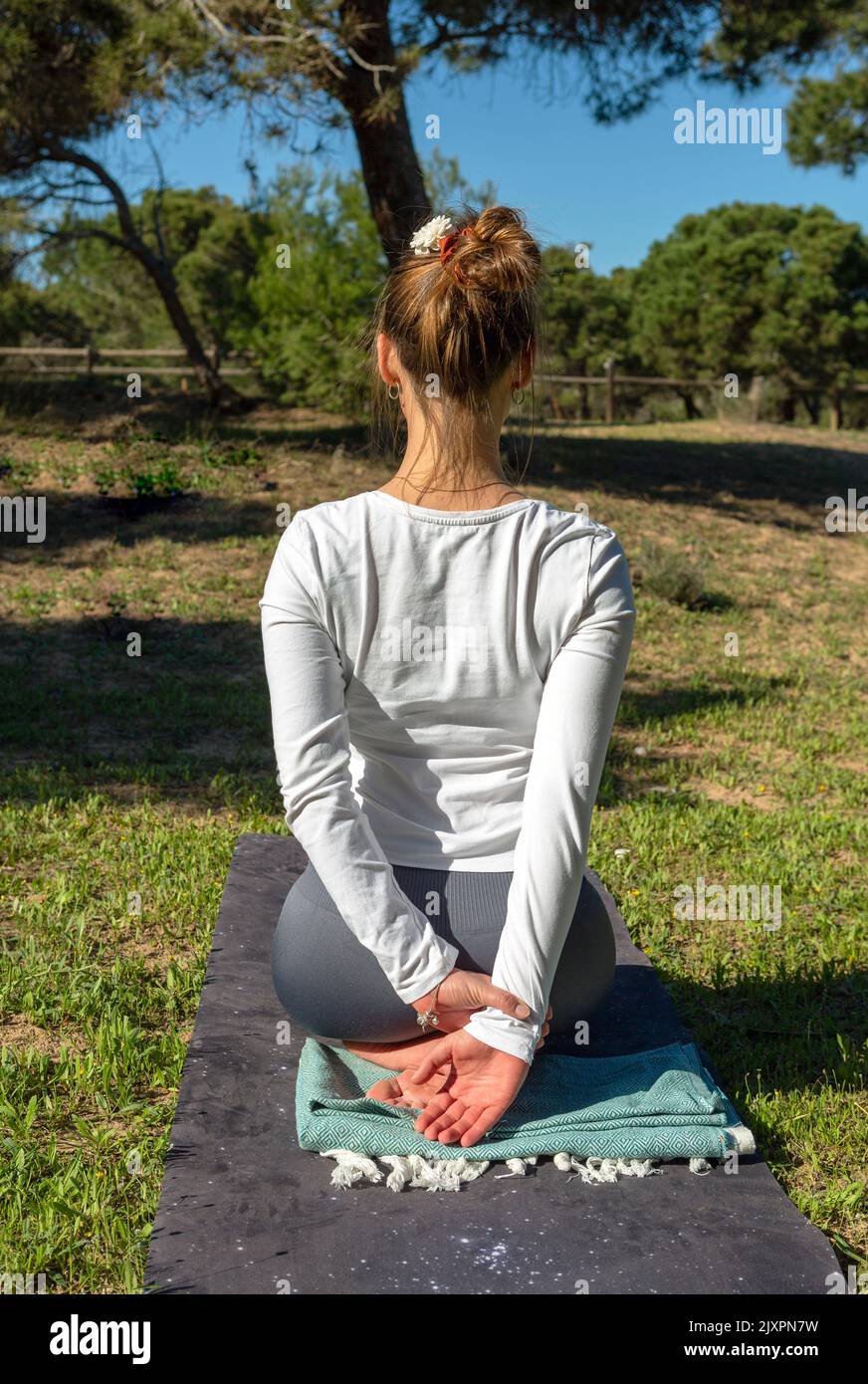 une femme faisant du yoga pose avec les bras derrière elle dans le dos dans la nature Banque D'Images