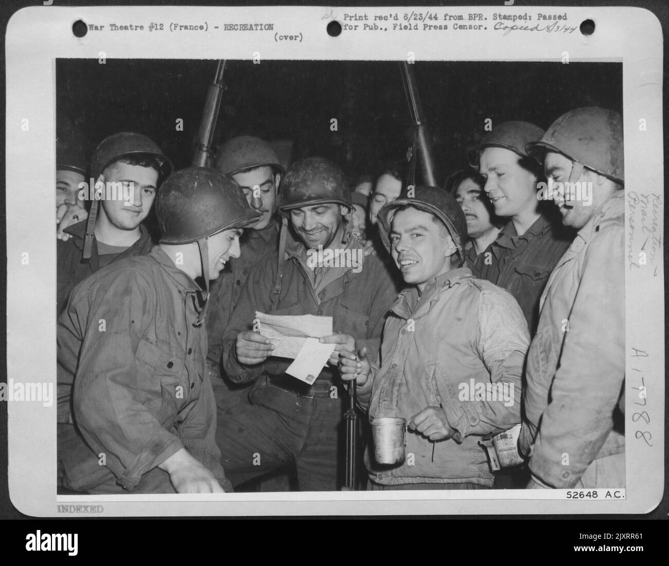 LETTRE DANS AUCUNE TERRE-CPL. Stephen Salak (au centre) de McKeesport, en Pennsylvanie, a reçu sa première lettre de la maison, mais parce que ses copains, tous les membres d'un Bataillon de génie de l'aviation de 9th de l'AF n'avaient pas reçu de courrier du tout, il partage les secrets de famille Banque D'Images
