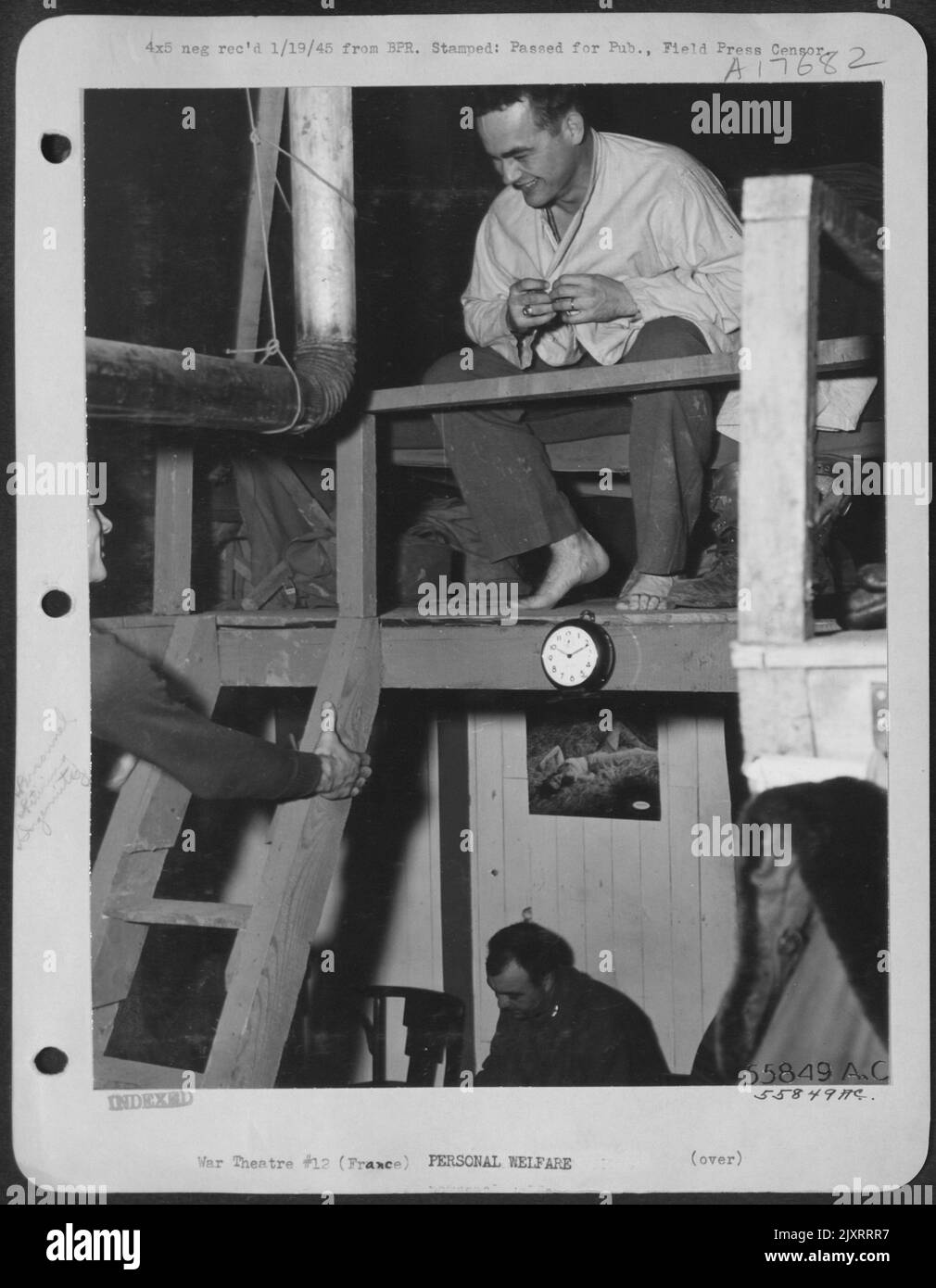 Grimpant l'échelle jusqu'au deuxième étage d'une tente pyramidale 'Shackteau' construite par des hommes dans une base de chasseurs-bombardiers de la neuvième Force aérienne en France, le lieutenant Robert J. Todd de Tampa, Floride, trouve le lieutenant Arthur F. d'Agostino de Newark, N.J., le battant au sac. Banque D'Images