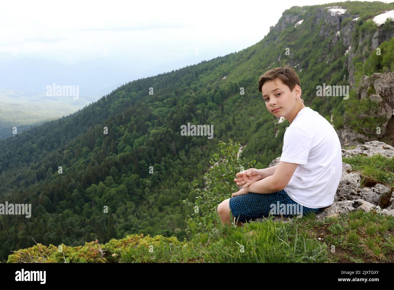 Enfant assis sur le rocher sur le plateau Lago-Naki en été, Adygea Banque D'Images
