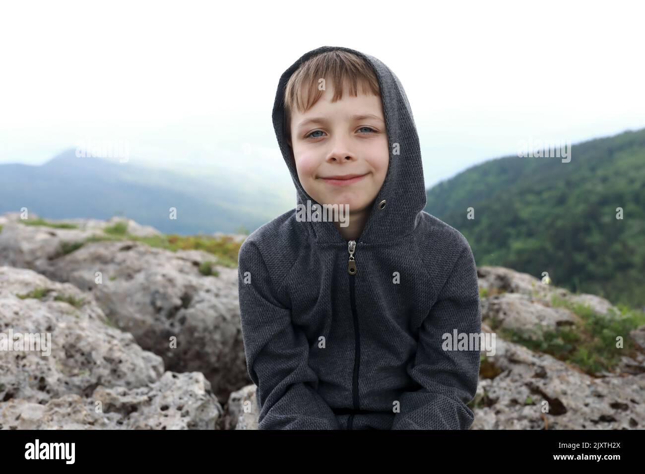 Enfant assis sur le rocher sur le plateau Lago-Naki en été, Adygea Banque D'Images