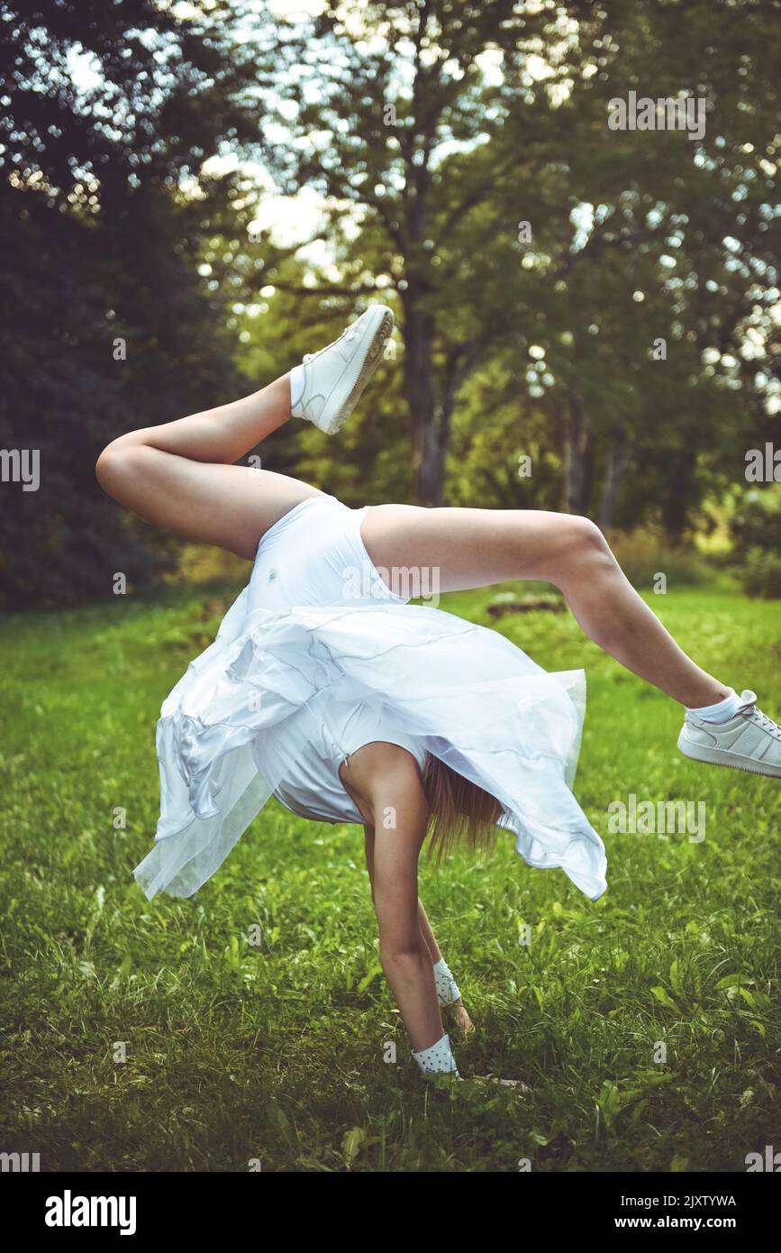 Fille athlète dans une robe blanche fait un saut dans l'air Banque D'Images