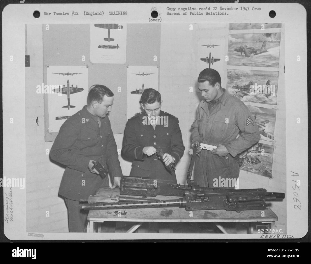 L'instruction de Gunnery à une base aérienne de 8th Bomber Command, en Angleterre, a été constante et prudente. Ici, un officier de la Force aérienne instruit le personnel enrôlement dans la bonne méthode d'assemblage D'Un Cal. .50. Mitrailleuse. Banque D'Images