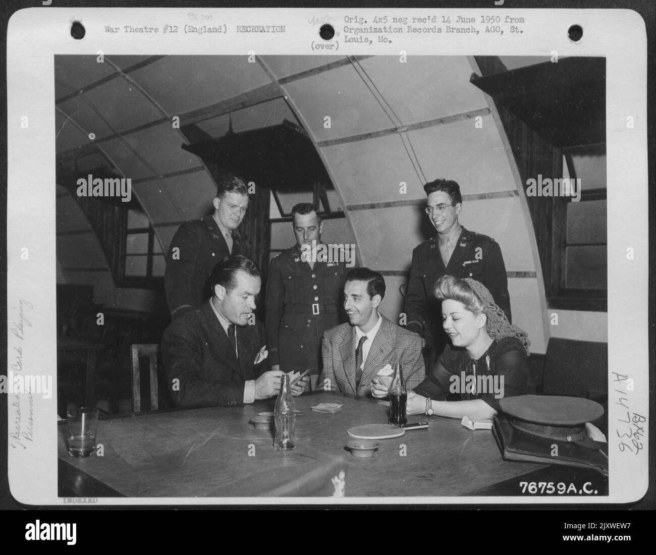 Tony Romano (Centre) et les officiers de l'Armée (contexte) regardent Bob Hope et Frances Langford pendant Un jeu de cartes à Matching, en Angleterre. Banque D'Images