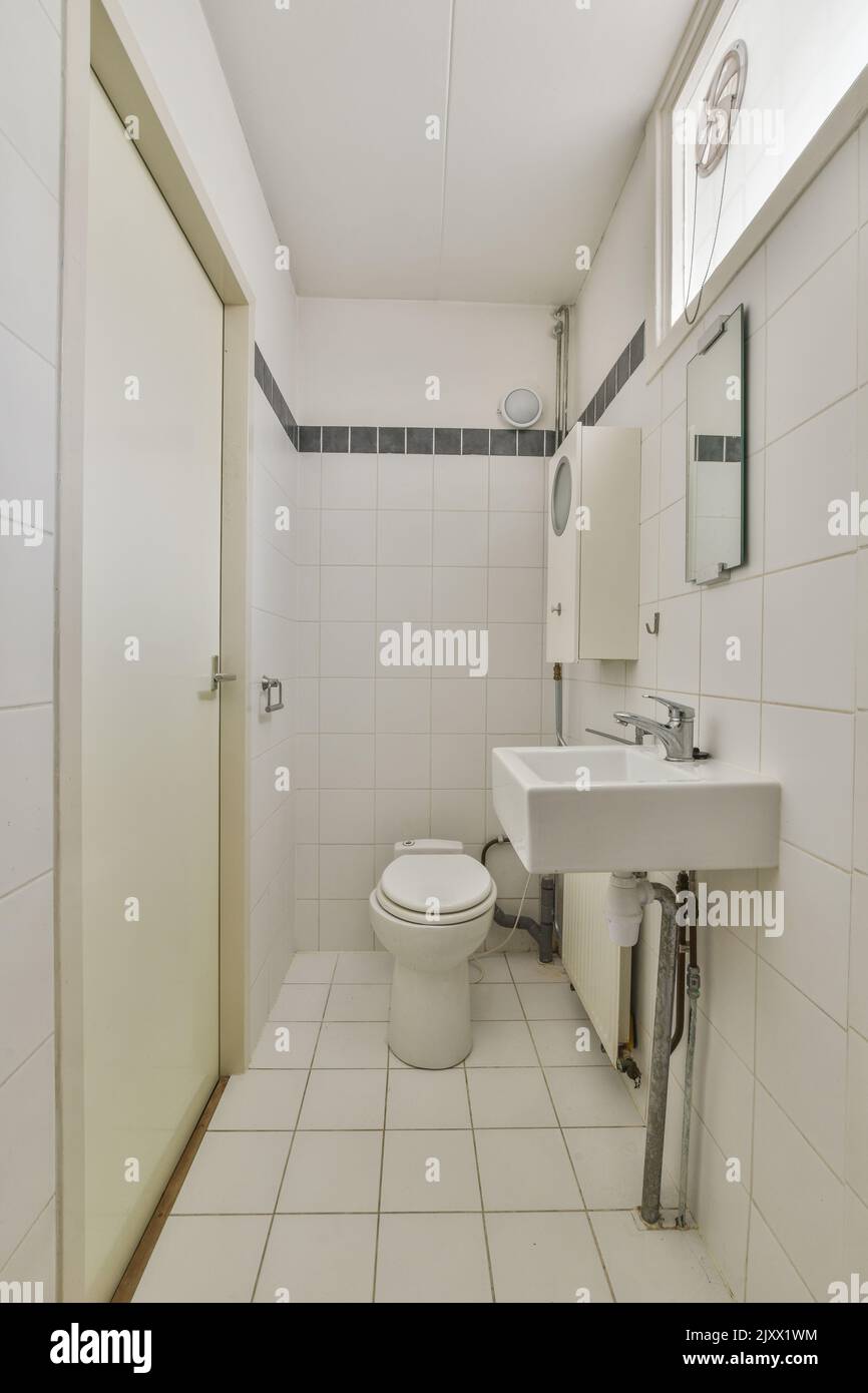 Toilettes et cabine de douche à chasse d'eau avec rideau situé près du lavabo et du miroir dans les toilettes Banque D'Images