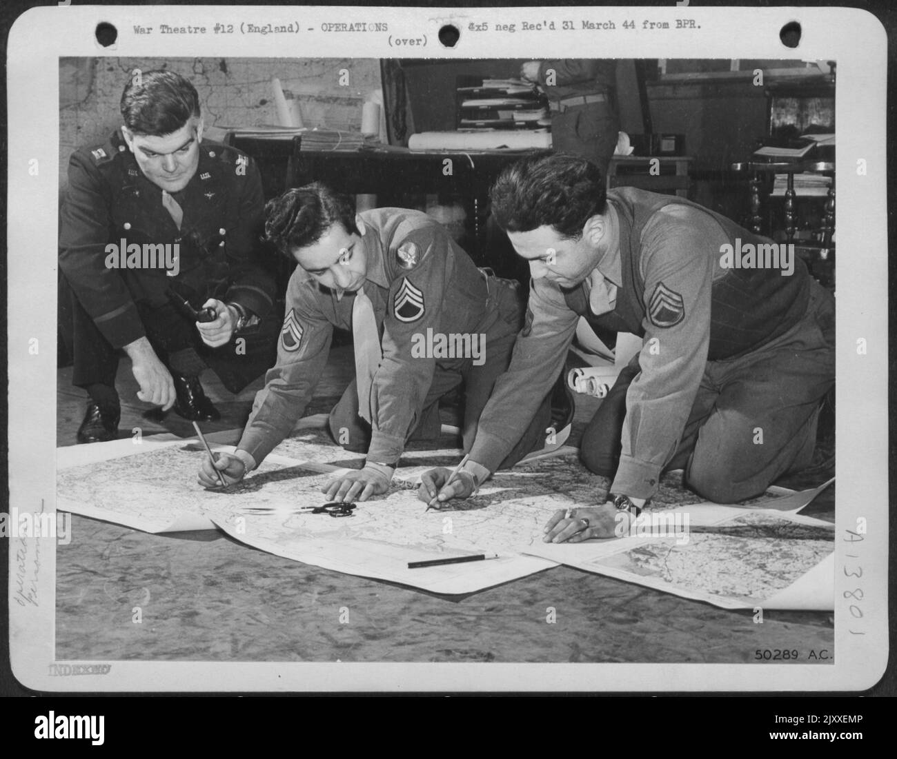 Après avoir reçu des ordres de Hdqs, les officiers et les hommes du S-2 (Group Intelligence) remplissent une multitude de détails : météo, chargement de la bombe, kilométrage de l'essence, point de visée, pore sur des photos aériennes de la cible, vérifiez les défenses ennemies à proximité et ensuite ils Banque D'Images