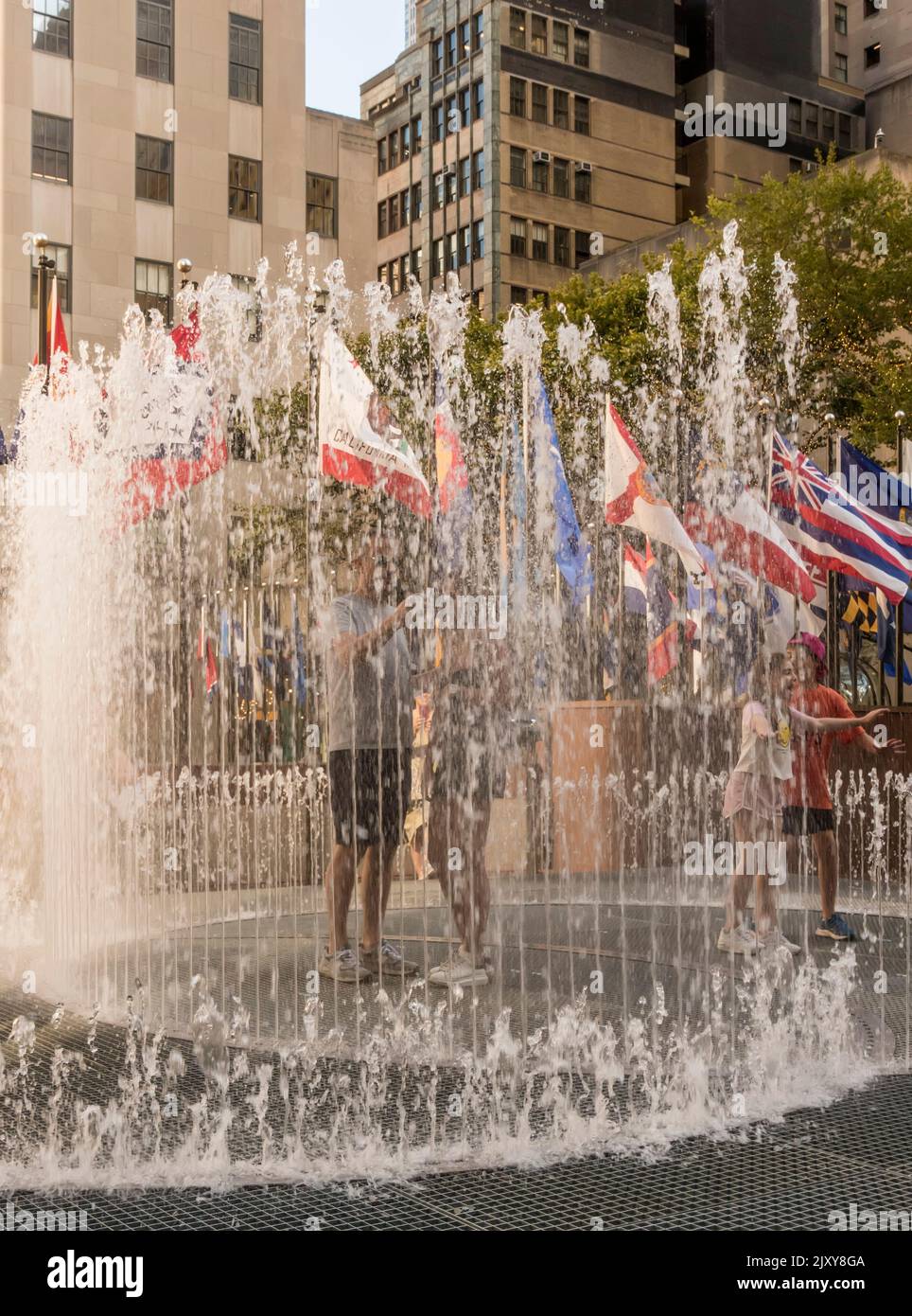 Personnes dans les fontaines d'eau lors d'une chaude journée d'été à Manhattan, New York, États-Unis Banque D'Images