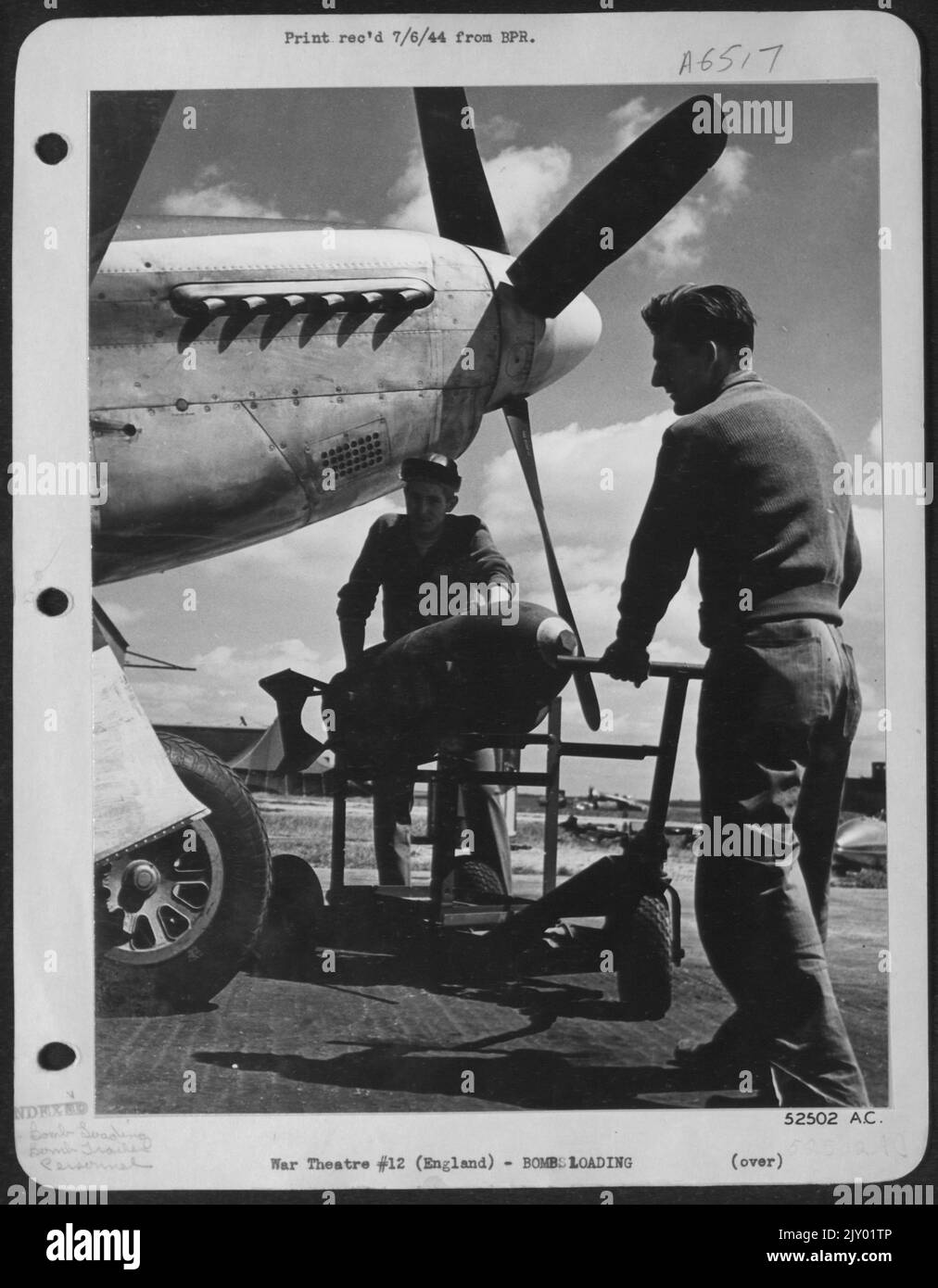 Cpl. Leroy Turner, d'Altoona, Pennsylvanie, (à gauche et Sgt. Henry A. Bucko, de Hammond, Ind., a attrapé une remorque à bombe avec un 500 limande sous le nez d'un P-51 Mustang 'Yahootie too' pour chargement sur l'avion piloté par le 1st Lt. John R. Bernert Banque D'Images