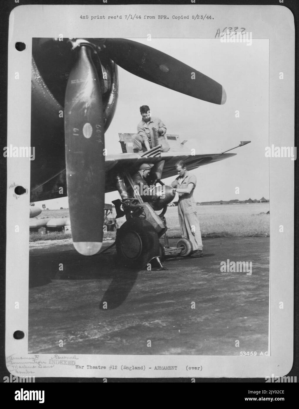 Armement de l'avion pour une mission sur la France. S/Sgt. Robert E. Robischon, de Syracuse (N.Y.), arme les quatre mitrailleuses de calibre .50, tandis que M/Sgt. James H. McGee, Pine Bluff, Ark., et Sgt. John A. Koval, Rochester, New York, attache la bombe.-Angleterre. Banque D'Images