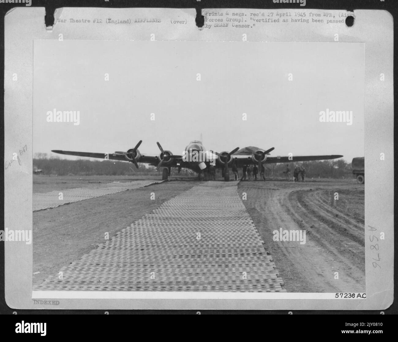 Après avoir été endommagé par l'ennemi Flak, ce Boeing B-17 « Forteresse volante » a été forcé à terre à courte distance de sa base sur Un petit champ d'Angleterre labouré avec des clôtures et des arbres offrant un danger extrême au pilote. Personnel d'Une base de réparation d'bombardier US 8th AF Rol Banque D'Images