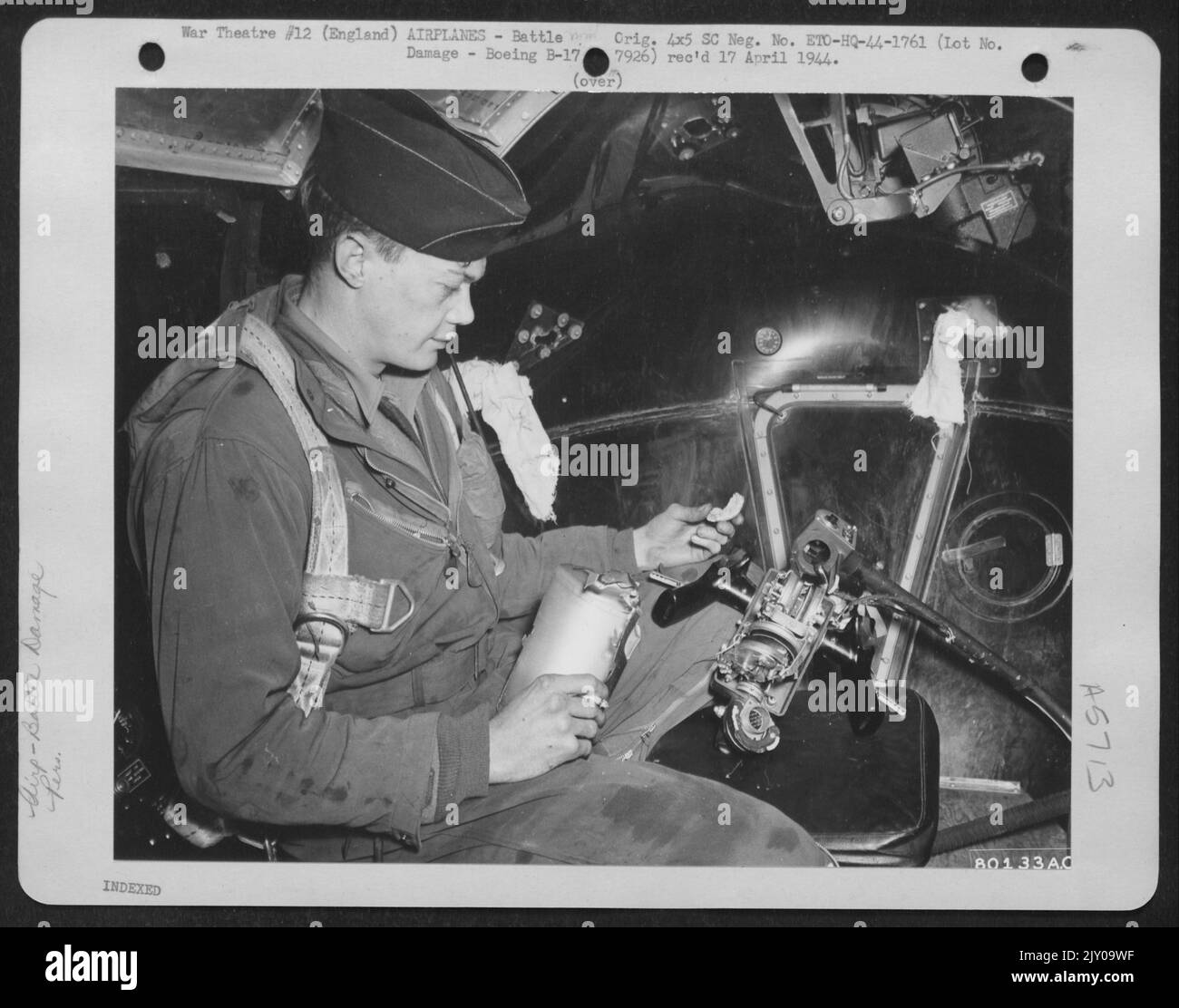 Lieutenant J.E. McLain, Pueblo, Colorado, Bombardier à bord de l'bombardier B-17 « Forteresse volante » de Boeing, « le moniteur », regarde les commandes de canon de Chin Turret qui ont été écrasées par Flak entrant dans le navire par le bec en verre de Plexi. Les flexibles ont été bloqués sur le passage Banque D'Images