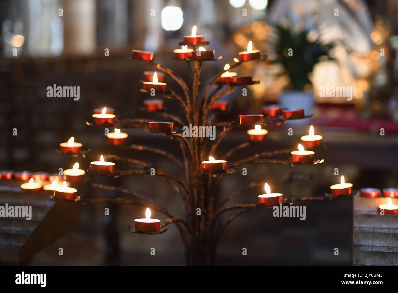 Beaucoup de bougies dans l'église catholique sombre Banque D'Images