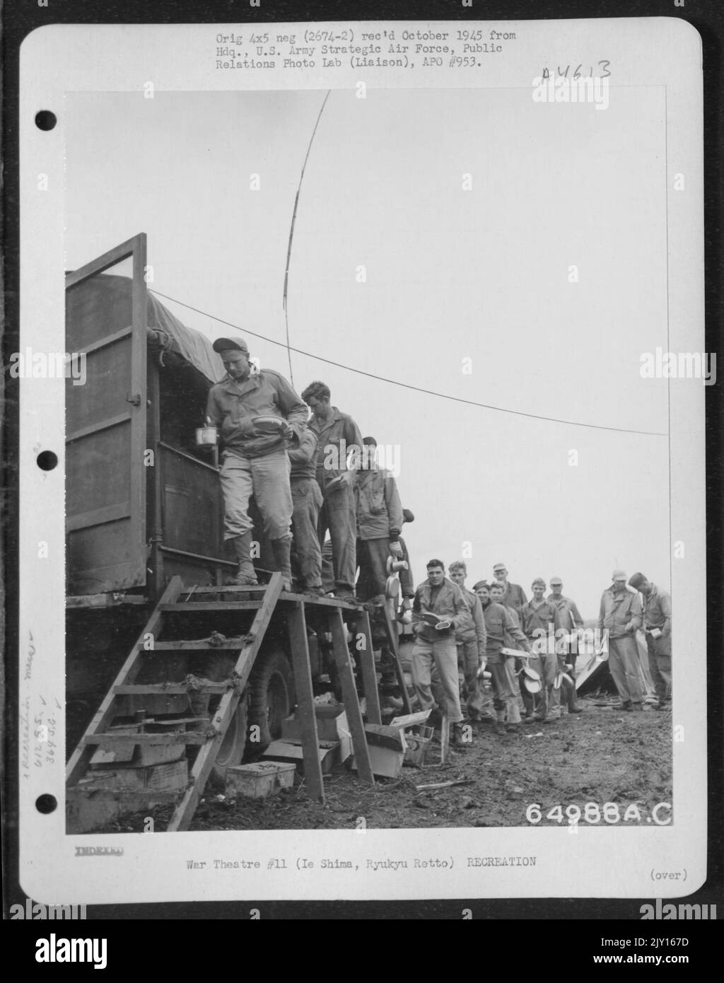 Des hommes du 612Th e Escadron de génie, 364th e Groupe de service, font monter la rampe de type Stile sur le côté du chariot Chuck pour prendre leur repas de midi. Le menu comprenait du Spam frit, des pois verts, du ragoût de viande et de légumes, des biscuits chauds, du café et de la ananas en conserve. Banque D'Images