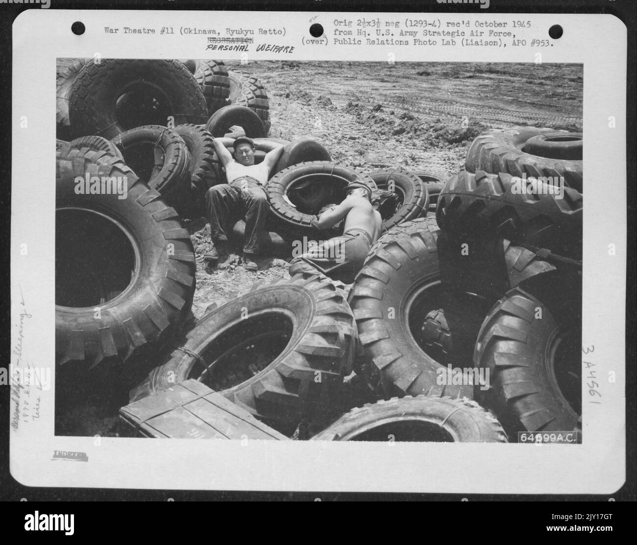 Entouré de pneus en caoutchouc épais, deux hommes du bataillon d'aviation d'ingénieurs de 1878Th 'Take A Break'. Okinawa, Ryukyu Retto, mai 1945. Banque D'Images
