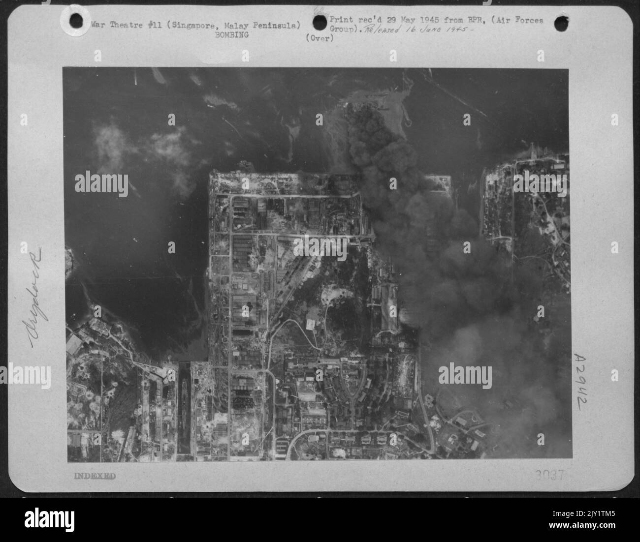 Un énorme nuage de fumée noire coule du pont flottant de Singapour et de son bateau après avoir été frappé par 1 000 bombes Pound larguées par des superforteresses B-29. Banque D'Images
