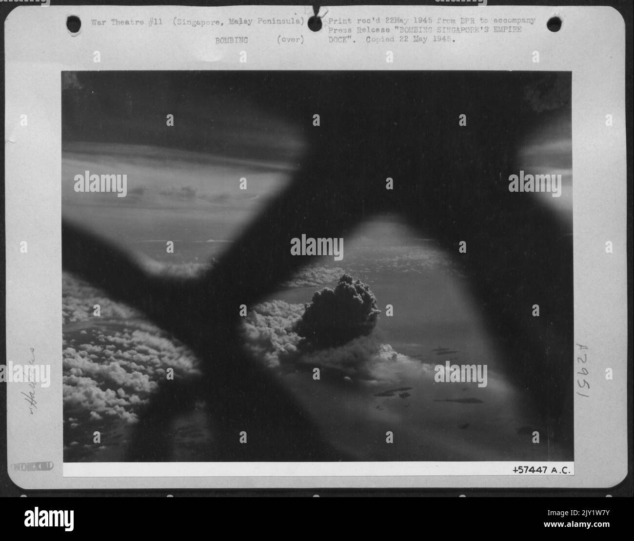 Bombarder l'Empire Dock de Singapour -- Une superforteresse B-29 du Brig Gen Roger M. Ramey le XXème Commandement de bombardier est prêt pour Une course au-dessus de la cible à Singapour tenue japonaise comme Un appareil photo dans son nez prend cette photo d'une énorme colonne de fumée noire qui s'élève de la Banque D'Images