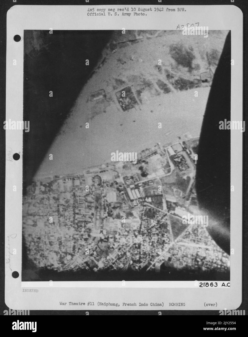 La fumée s'élève du quai et de l'entrepôt à Haiphong, Indo Chine française après un raid par le B-25s nord-américain de la Force aérienne de 14th. 9 août 1942. Banque D'Images