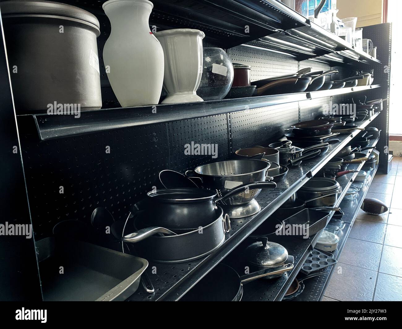 Les étagères d'une boutique thrift avec ustensiles de cuisine, casseroles et poêles Banque D'Images