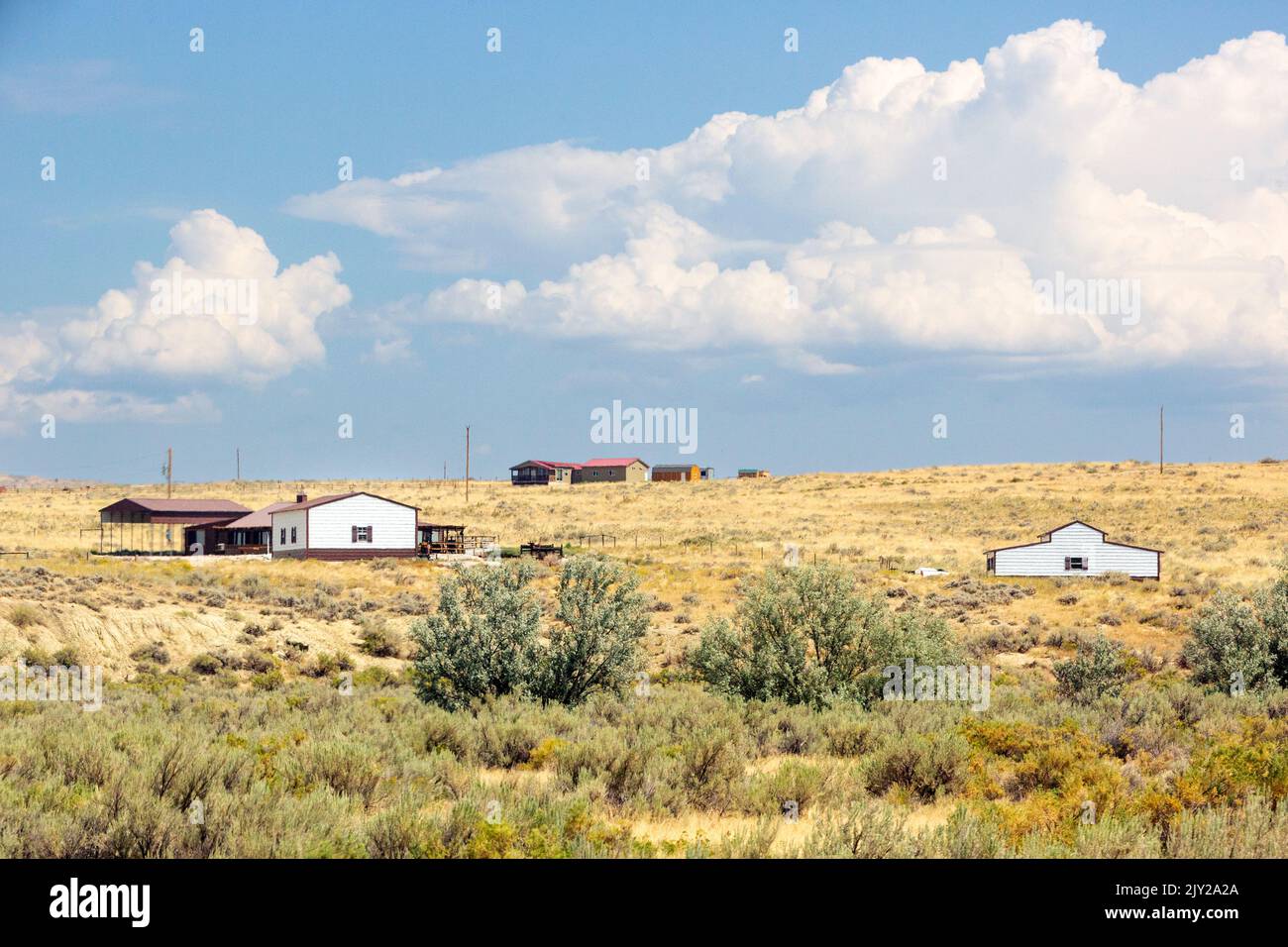 Paysage rural avec maisons de style ranch sur la steppe à la sagebrush des montagnes Rocheuses au nord de Cody, Wyoming Banque D'Images