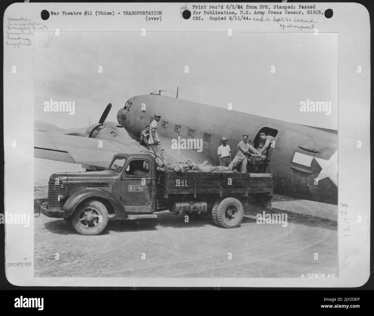 Un avion de transport de marchandises C-47 de Douglas est chargé à une base avancée de la Force aérienne 14th en vue de son départ pour une mission de largage de l'offre. Le riz, les fournitures médicales et les munitions sont déposés par « chute » sur des cibles prédisposées. G à D sont : Banque D'Images