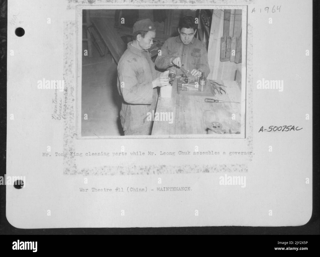 M. Tong Ying nettoie les pièces pendant que M. Leong Chuk assemble un gouverneur. Banque D'Images