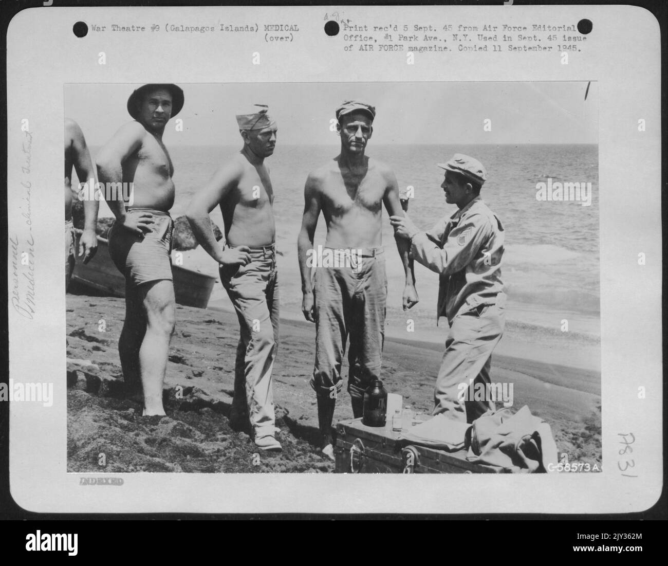 'Tenez-vous immobile et regardez de l'autre côté. Il ne fera pas mal Un peu", conseille sans erreur le S/Sgt. George Mohr, d'Oakland, Californie, alors qu'il jabs l'aiguille dans son bras de patient. « doc », comme on l'appelle naturellement, a déjà fait trois voyages dans les avant-postes de l'île et Banque D'Images