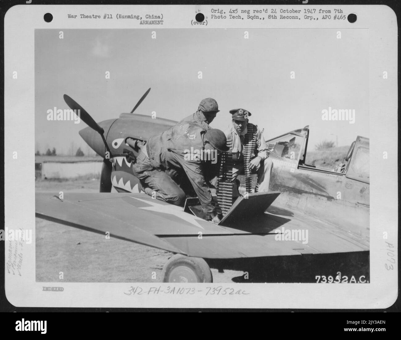 Le colonel Robert L. Scott, Jr. (Macon, Géorgie) du 23rd Fighter Group, aide le S/Sgt. R. Fuller du Texas et Sgt. J. Teague, de la Follette, Tennessee, charge ses armes avant la dernière chasse japonaise du colonel Scott avant de quitter Kunming, en Chine, pour les États-Unis Banque D'Images