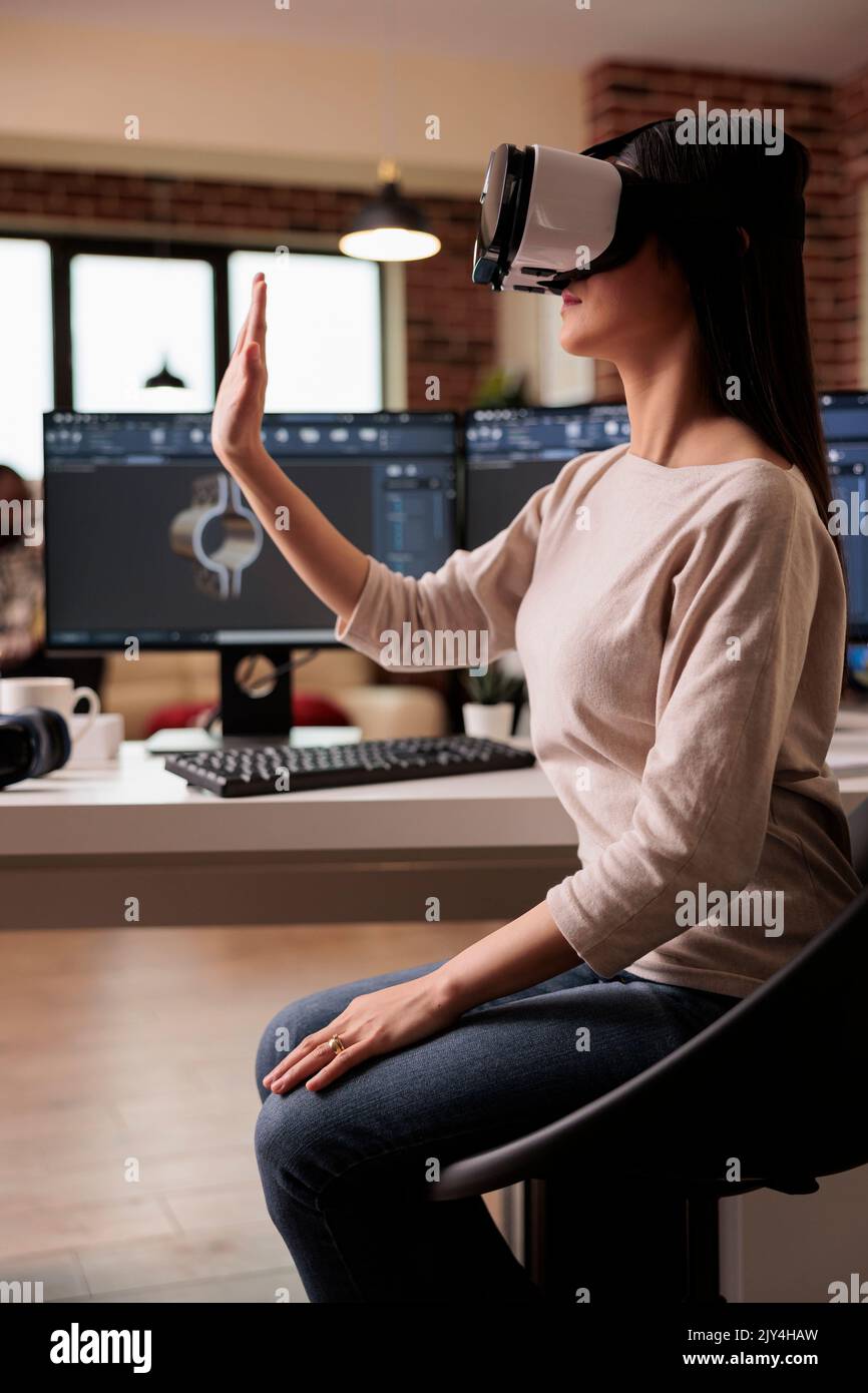 Un technicien asiatique travaillant avec des lunettes vr développe des produits, contribuant ainsi à la production de machines industrielles. Un ingénieur CAO fabrique un modèle Gears avec un micro-casque et un logiciel Virtual Reality 3D. Banque D'Images